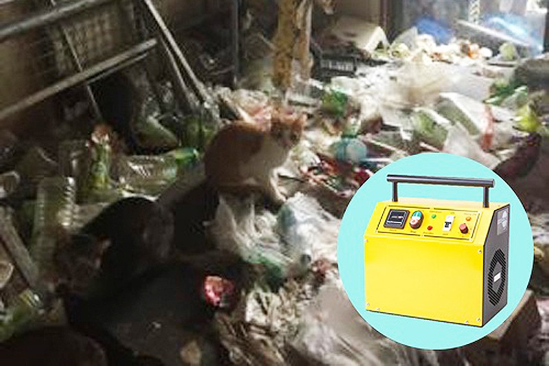 室内に生活ごみが大量に散乱し、その中に数匹の猫がいるゴミ屋敷の様子。右下には消臭用の業務用オゾン脱臭機の製品画像が合成されている。